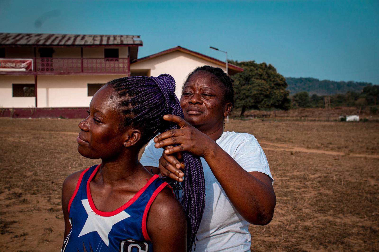 A woman braiding a girl's hair